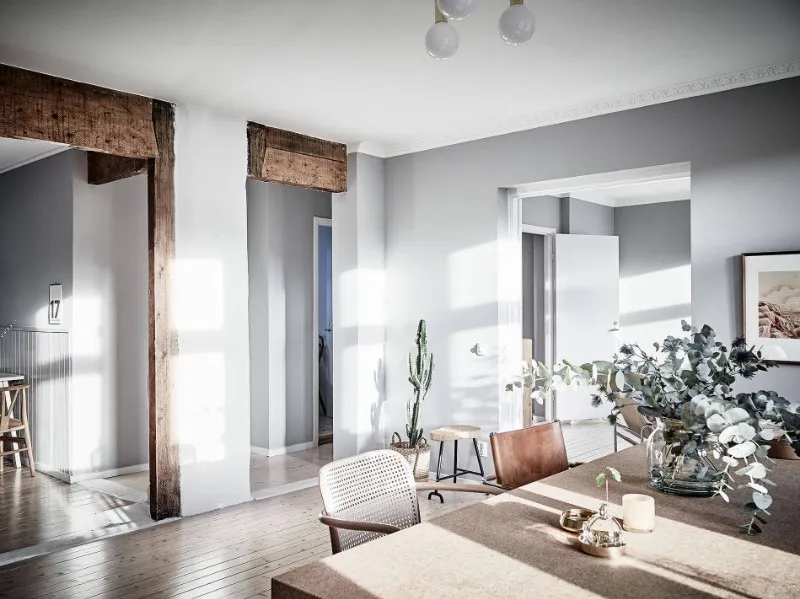 Open apartment layout showing dining furniture and natural wood architectural details