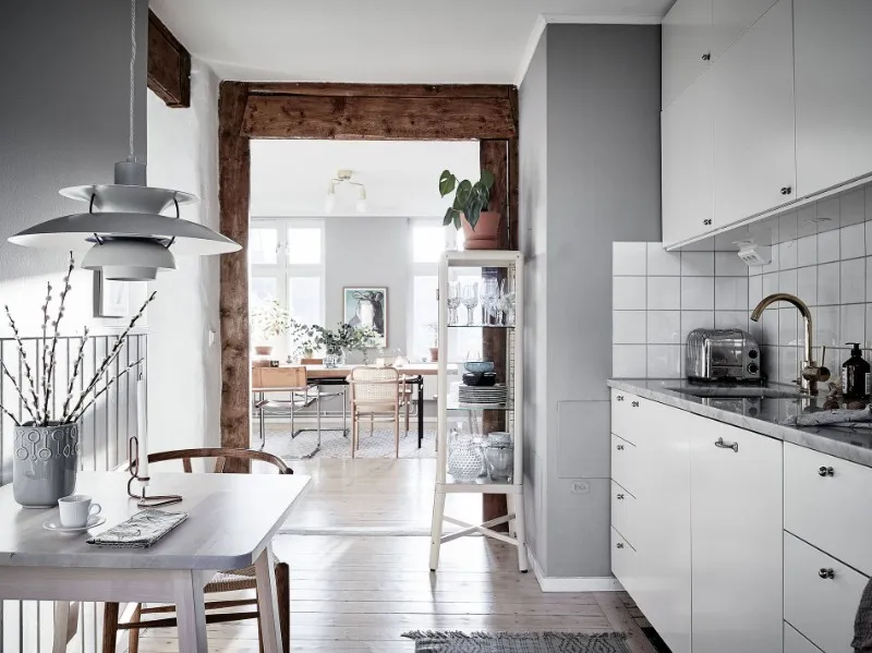 White apartment kitchen cabinetry connected to an open dining area