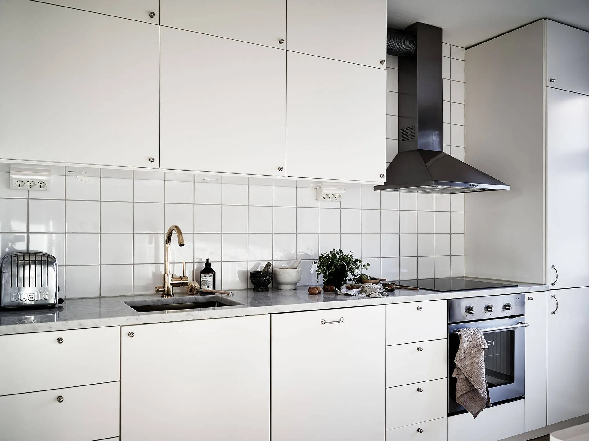 Custom white kitchen cabinets with stone countertop and integrated appliance openings